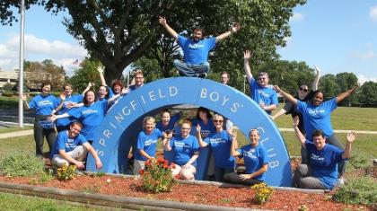 A group of volunteers posed around the Springfield Boys Club sign