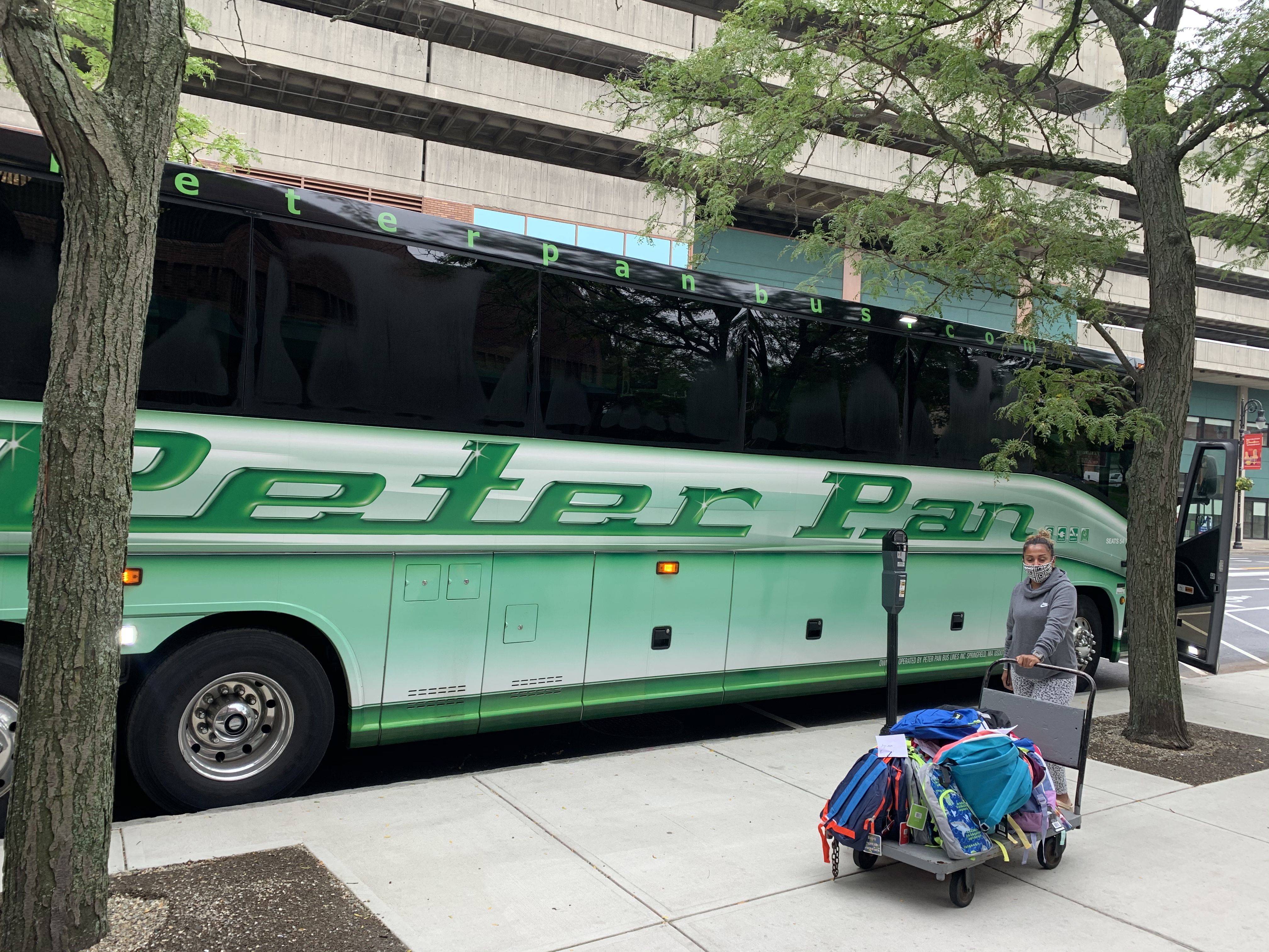 A bus being loaded with backpacks