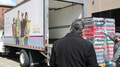 Mayor Domenic Sarno (center) observes Tom Leporati of the Food Bank of Western Massachusetts loading a pallet of food.